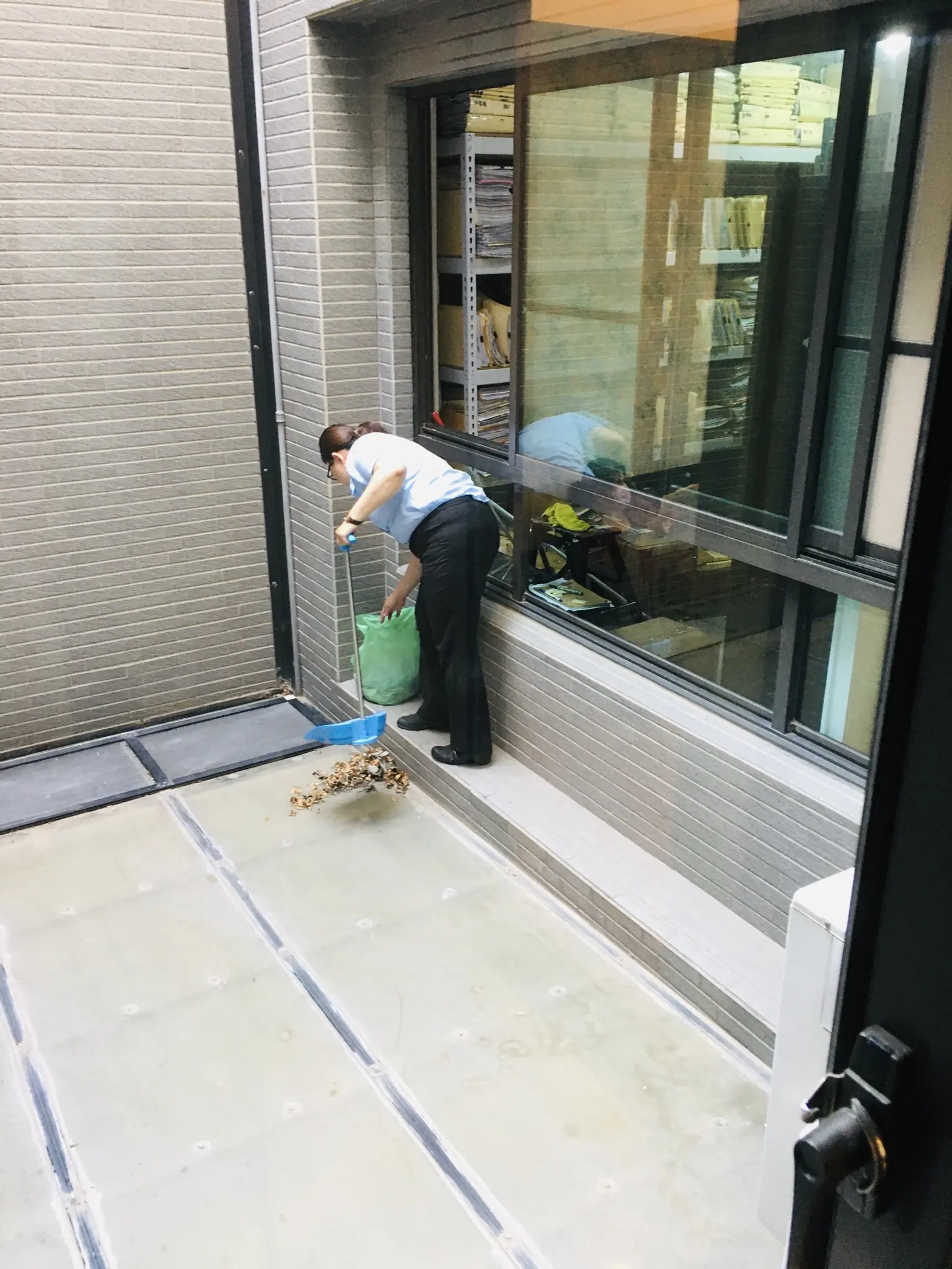 主婦打掃陽台樹葉跟垃圾