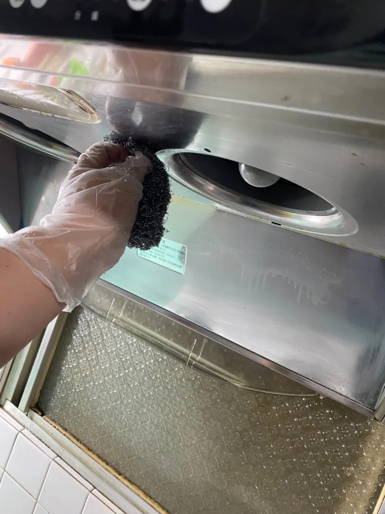有油垢的抽油煙機，已經噴上清潔劑靜製10-20分鐘油垢軟化，戴上手套準備用鐵絲球刷洗